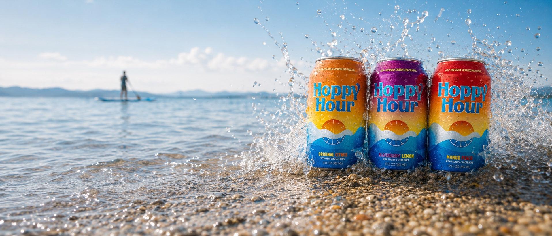 Three Hoppy Hour cans splashing in lake water