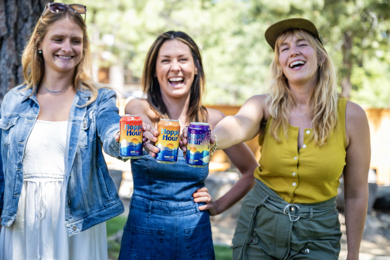 Friends holding Hoppy Hour cans