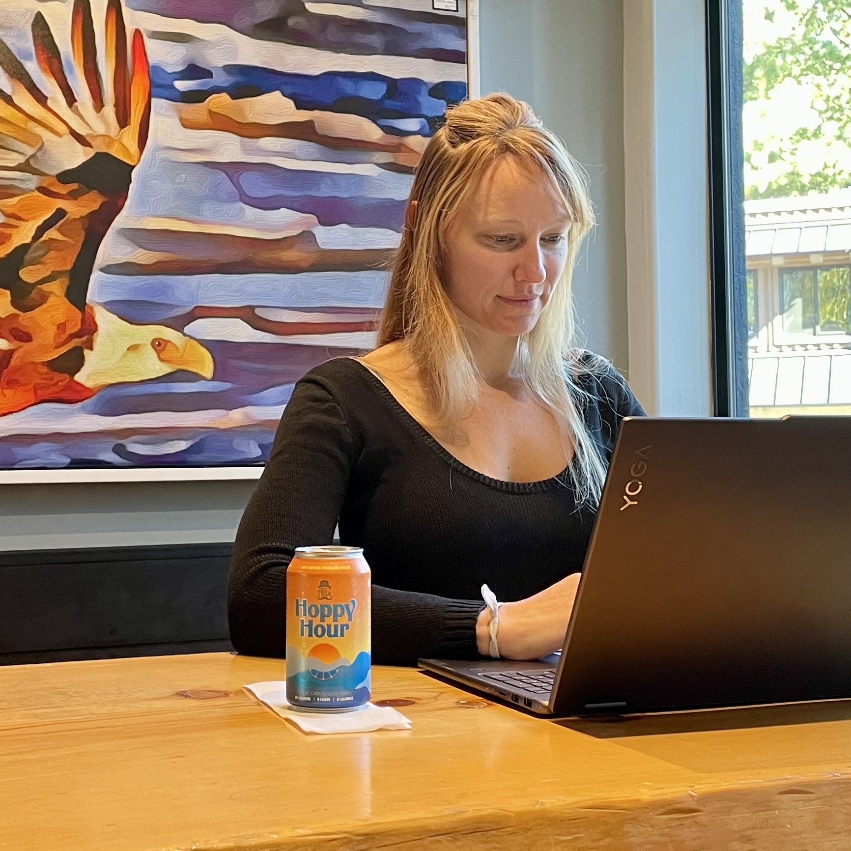Hoppy Hour can beside a laptop during a workday